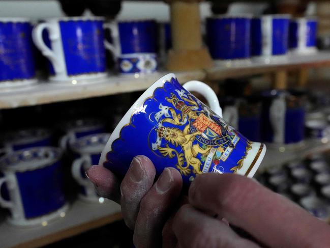 A pottery worker works on official chinaware produced for the coronation of Britain's King Charles III and Camilla. Picture: AFP