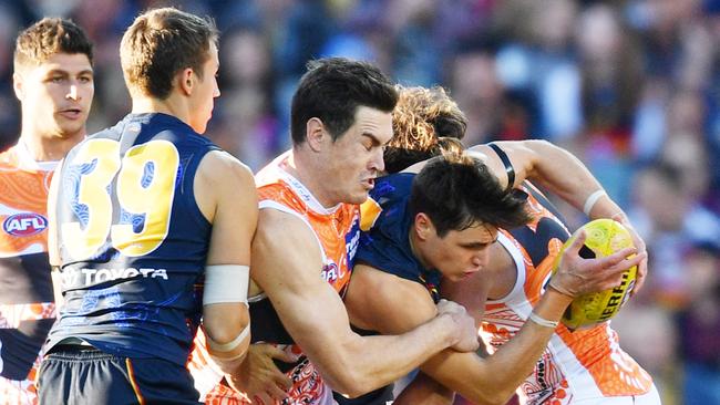 Jake Kelly of the Crows tries to bust past Giant Jeremy Cameron. Picture: AAP Image/David Mariuz