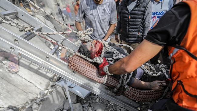 Palestinian citizens carry out search and rescue operations in the destruction caused by Israeli air strikes. Picture: Ahmad Hasaballah