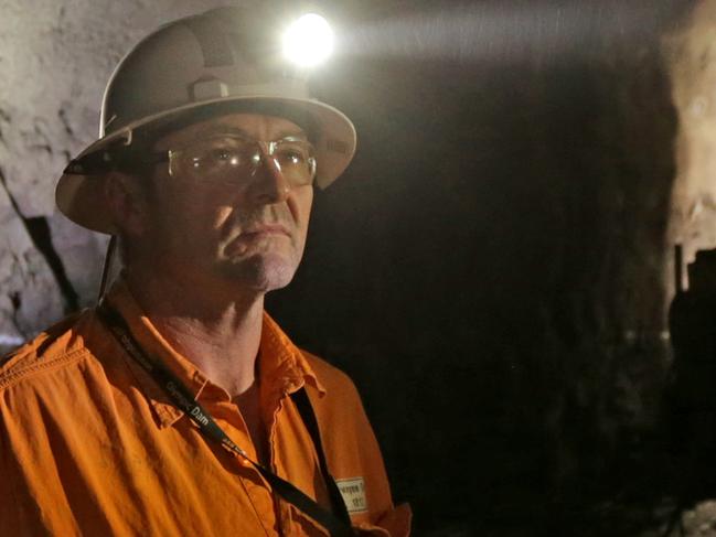 Dwayne Gum underground as a header works in the background to drill into ore deposits at BHP Billiton's Olympic Dam project in South Australia. The mine produces Copper, Gold, Silver & Uranium.