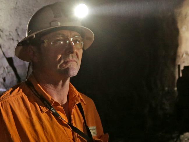 Dwayne Gum underground as a header works in the background to drill into ore deposits at BHP Billiton's Olympic Dam project in South Australia. The mine produces Copper, Gold, Silver & Uranium.