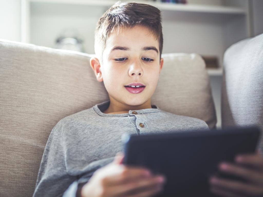 Boy using digital tablet in sofa at home