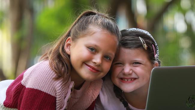 Casula Public School students Baylee Dwyer and her sister Bronte Dwyer use their computer for their school lessons. Picture: Angelo Velardo