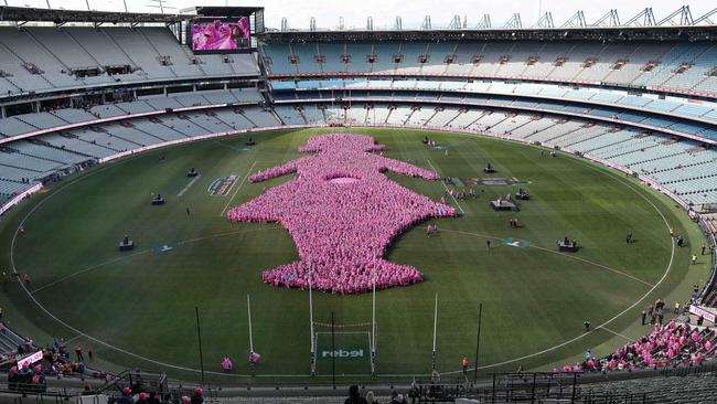 Thousands of Breast Cancer survivors and their families help make the shape of the iconic pink lady at the MCG in support of the Field of Women event. Picture: Michael Klein.