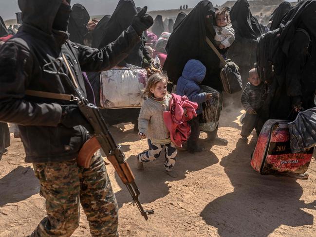 TOPSHOT - Women and children evacuated from the Islamic State (IS) group's embattled holdout of Baghouz arrive at a screening area held by the US-backed Kurdish-led Syrian Democratic Forces (SDF), in the eastern Syrian province of Deir Ezzor, on March 6, 2019. - Veiled women carrying babies and wounded men on crutches hobbled out of the last jihadist village in eastern Syria on March 6 after US-backed forces pummelled the besieged enclave. The Syrian Democratic Forces leading the assault expected more fighters to surrender with their families in tow before moving deeper in the Islamic State group's last redoubt. (Photo by Bulent KILIC / AFP)