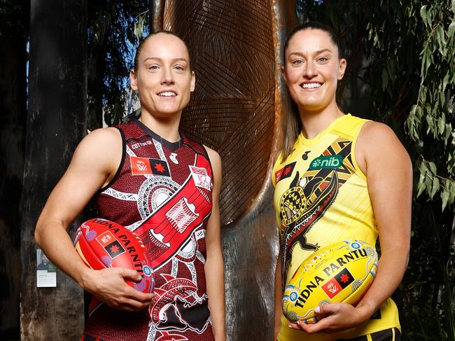 MELBOURNE, AUSTRALIA - OCTOBER 21: Stephanie Cain, Co-Captain of the Bombers and Maddie Shevlin of the Tigers pose in front of 'The Sacred Tree of our Songlines' created by Gunnai and Waradjurie man Robert Michael Young during the 2024 AFLW Indigenous Round Launch at Melbourne Museum on October 21, 2024 in Melbourne, Australia. (Photo by Michael Willson/AFL Photos via Getty Images)