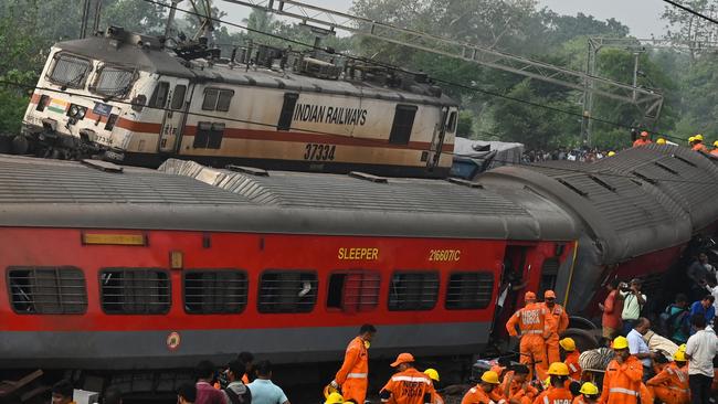 Rescue workers gather near damaged carriages at the accident site. Picture: AFP