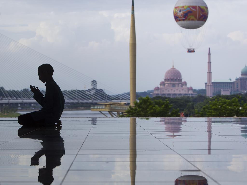 A Malaysian Muslim man is silhouetted as he performs his prayers at a mosque in Putrajaya, Malaysia on June 17, 2015. [Picture: AAP