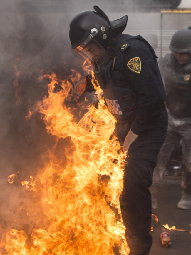 A riot police officer is surrounded in flames after a clash with protesters during a rally calling on Mexican authorities to continue searching for the students. Picture: Miguel Tovar/LatinContent/Getty Images