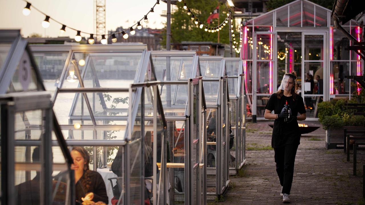 A waitress wearing a protective face shield serves people having dinner in a so-called quarantine greenhouses in Amsterdam. Picture: Robin van Lonkhuijsen/ANP/AFP