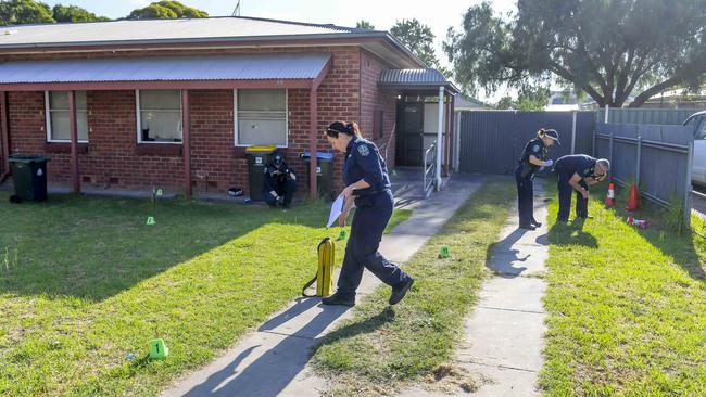 Police scour the Housing Trust unit at Kilburn for clues after it was peppered with shots. Picture: Roy VanDerVegt