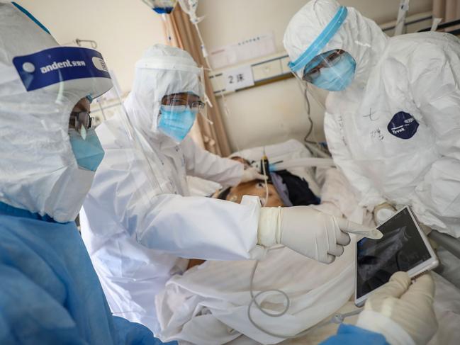 A doctor checks a patient who has Covid-19 at the Wuhan Red Cross Hospital in Wuhan. Picture: AFP