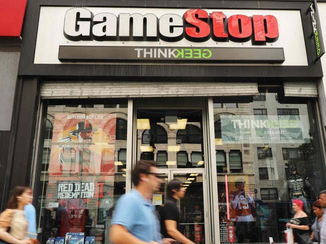 (FILES) In this file photo taken on September 15, 2019 people pass a GameStop store in lower Manhattan in New York City. G - GameStop continued its wild Wall Street ride on January 25, 2021 with a dizzying climb seemingly powered by online chatter about the struggling video game retailer with a devoted fan base. GameStop shares were up 70 percent at one point in morning trades, after ending last week with a surge in price and rocketing some 800 percent in the past three months. (Photo by SPENCER PLATT / GETTY IMAGES NORTH AMERICA / AFP)