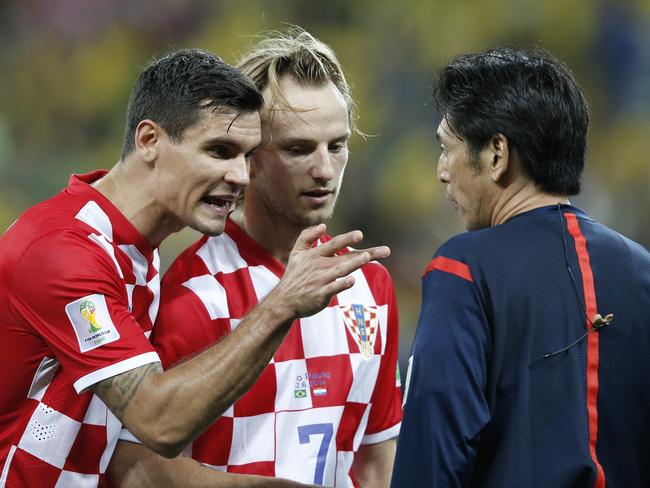 Croatia's defender Dejan Lovren (L) and Croatia's midfielder Ivan Rakitic in a heated exchange with Japanese referee Yuichi Nishimura during a Group A match between Brazil and Croatia.