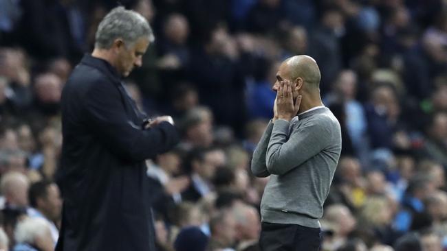Manchester United manager Jose Mourinho, left, checks his watch next to Manchester City coach Pep Guardiola