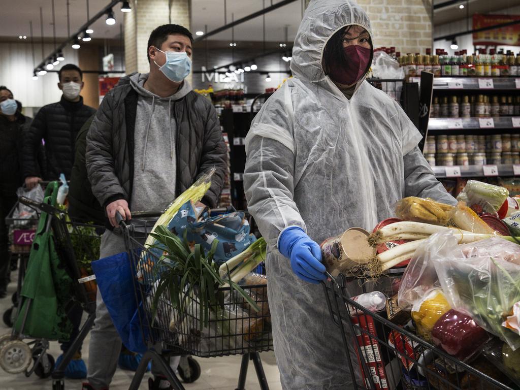 Residents wear protective masks as they line up in the supermarket in Wuhan. Picture: Stringer/Getty Images)