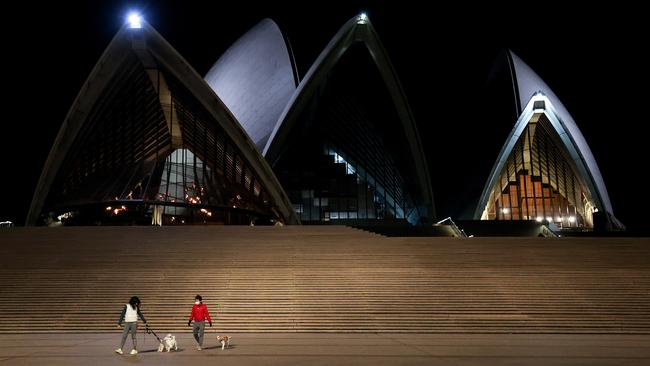 People walk dogs at an empty Sydney Opera House which is closed due to Covid-19. Picture: Getty