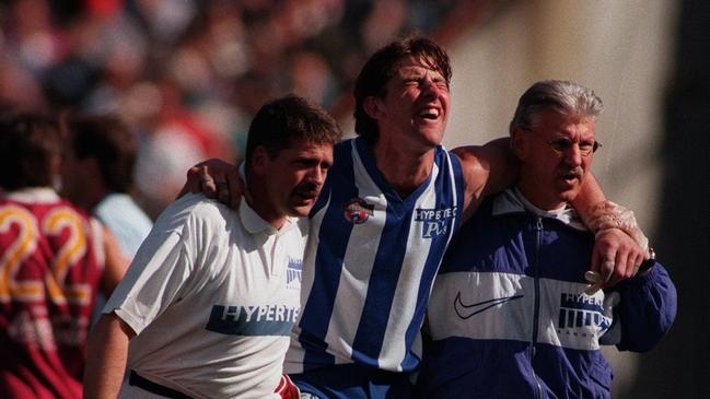 Corey McKernan being helped from the field during the 1996 preliminary final win over Brisbane.