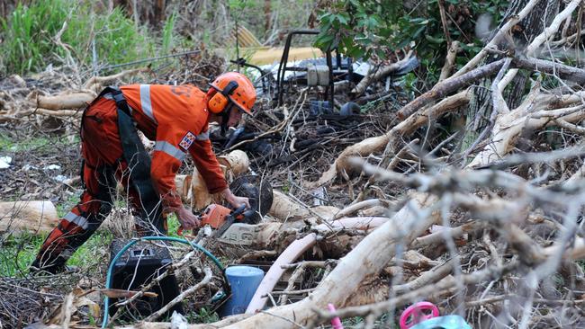 SES volunteer Stefan Buick from Canberra clears tree litter from a house at Tully Heads in the wake of Cyclone Yasi in 2011. Picture: Evan Morgan