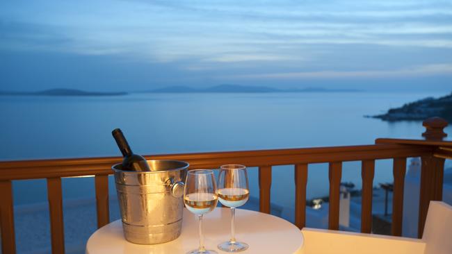 Glasses of wine with an ice bucket on a balcony at sunset