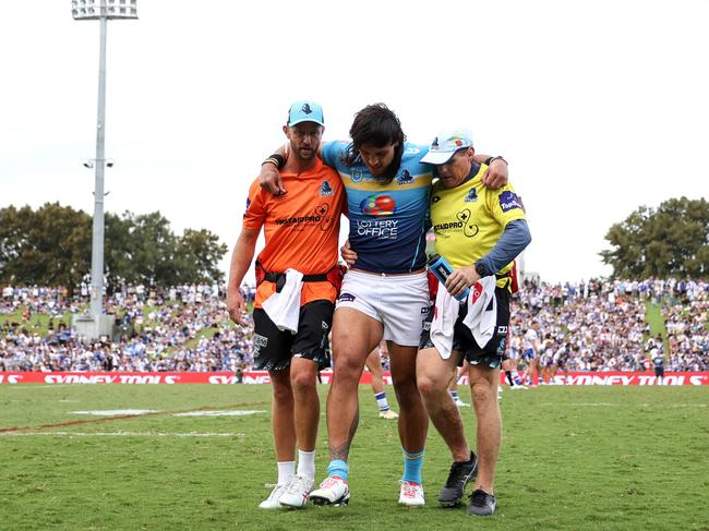 STino Fa'asuamaleaui of the Titans is helped from the field after suffering a knee injury playing the Bulldogs at Belmore Sports Ground. Picture: Getty Images