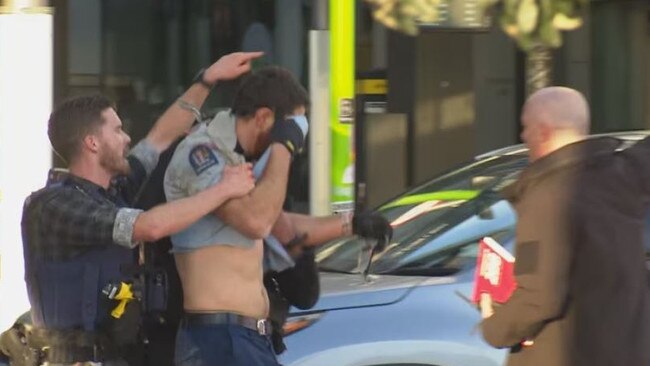 An injured police officer is led away from the scene. Picture: 1News