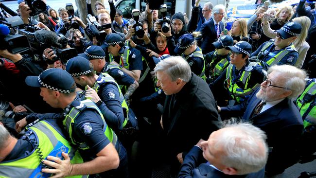 Cardinal Pell is flanked by police as he arrives at court. Picture: Mark Stewart