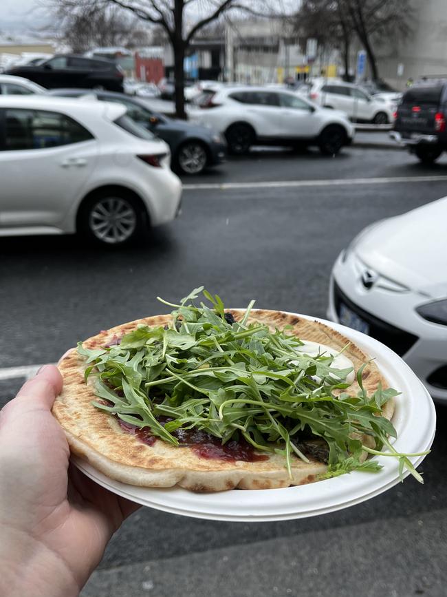 A wood-fired flatbread from Flamecake. This Fun Guy option, features grilled halloumi nestled into pesto mushrooms, rocket and a spoonful of pepperberry relish. Picture: Alix Davis