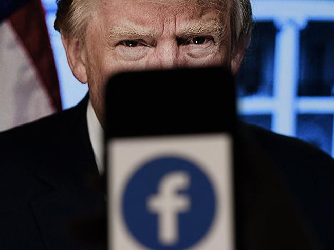 (FILES) In this file photo illustration, a phone screen displays a Facebook logo with the official portrait of former US President Donald Trump on the background, on May 4, 2021, in Arlington, Virginia. - Facebook's independent oversight board on May 5, 2021 upheld the platform's ban on former US president Donald Trump but called for a further review of the penalty within six months. The board, whose decisions are binding on the leading social network, said Trump "created an environment where a serious risk of violence was possible" with his comments regarding the January 6 rampage by his supporters at the US Capitol. (Photo by Olivier DOULIERY / AFP)