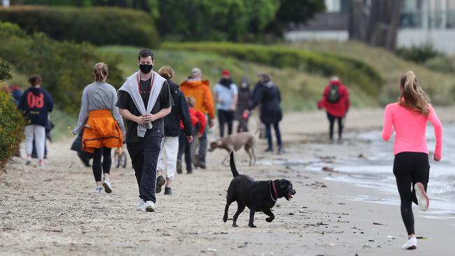 Mask-wearing Tasmanians exercising at Nutgrove Beach in Sandy Bay during a Covid lockdown in Tasmania in October 2021. Picture: Nikki Davis-Jones