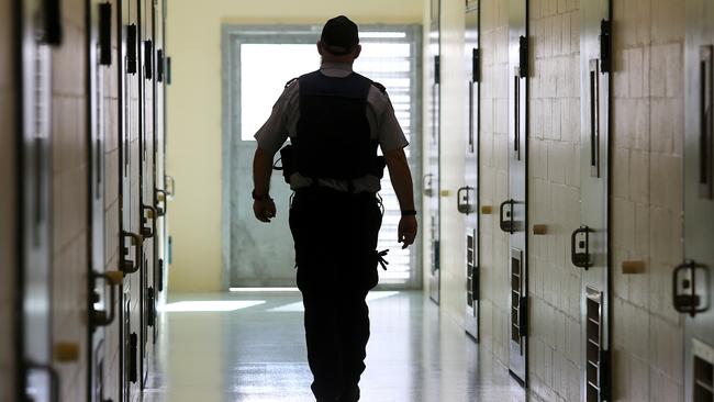 A corrections officer walks down a cell corridor. (AAP Image/Jono Searle)