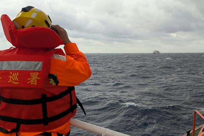 A Taiwan Coast Guard crewmember monitors a Chinese coast guard vessel in waters east of Taiwan as China holds its biggest maritime drills in years