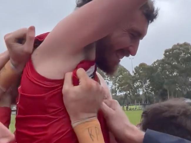 Daniel Weetra celebrates his 100th goal with teammates and fans.