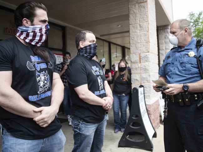 A police officer talks to gym owners in New Jersey. Picture: AP