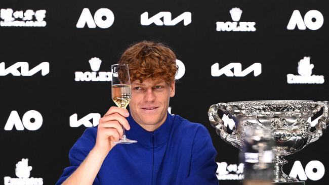 This handout picture released by Tennis Australia on January 27, 2025, shows Italy's Jannik Sinner raises his glass to toast during a press conference after defeating Germany's Alexander Zverev during their men's singles final match on day fifteen of the Australian Open tennis tournament in Melbourne. (Photo by Vince CALIGIURI / TENNIS AUSTRALIA / AFP) / RESTRICTED TO EDITORIAL USE - MANDATORY CREDIT "AFP PHOTO / TENNIS AUSTRALIA / VINCE CALIGIUR " - NO MARKETING NO ADVERTISING CAMPAIGNS - DISTRIBUTED AS A SERVICE TO CLIENTS