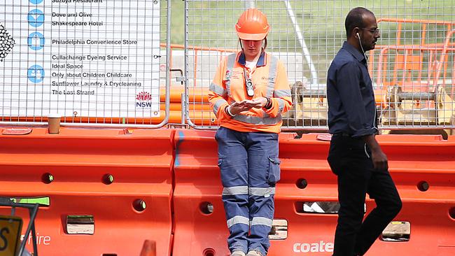 A light rail worker checks her phone in Surry Hills. The Daily Telegraph does not suggest the woman was dodging work. Workers are contacting government officials to dob in constractor Acciona for “go slow” orders.