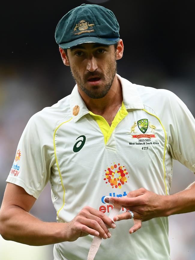 \Mitchell Starc tapes his finger.