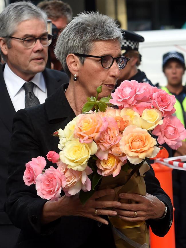 The Governor of Victoria Linda Dessau lays flowers at the corner of Bourke St and Elizabeth St this morning. Picture: Nicole Garmston