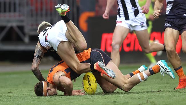 Collingwood's Jeremy Howe injures his knee by colliding with Giant Jacob Hopper during a game last season. Picture: Phil Hillyard