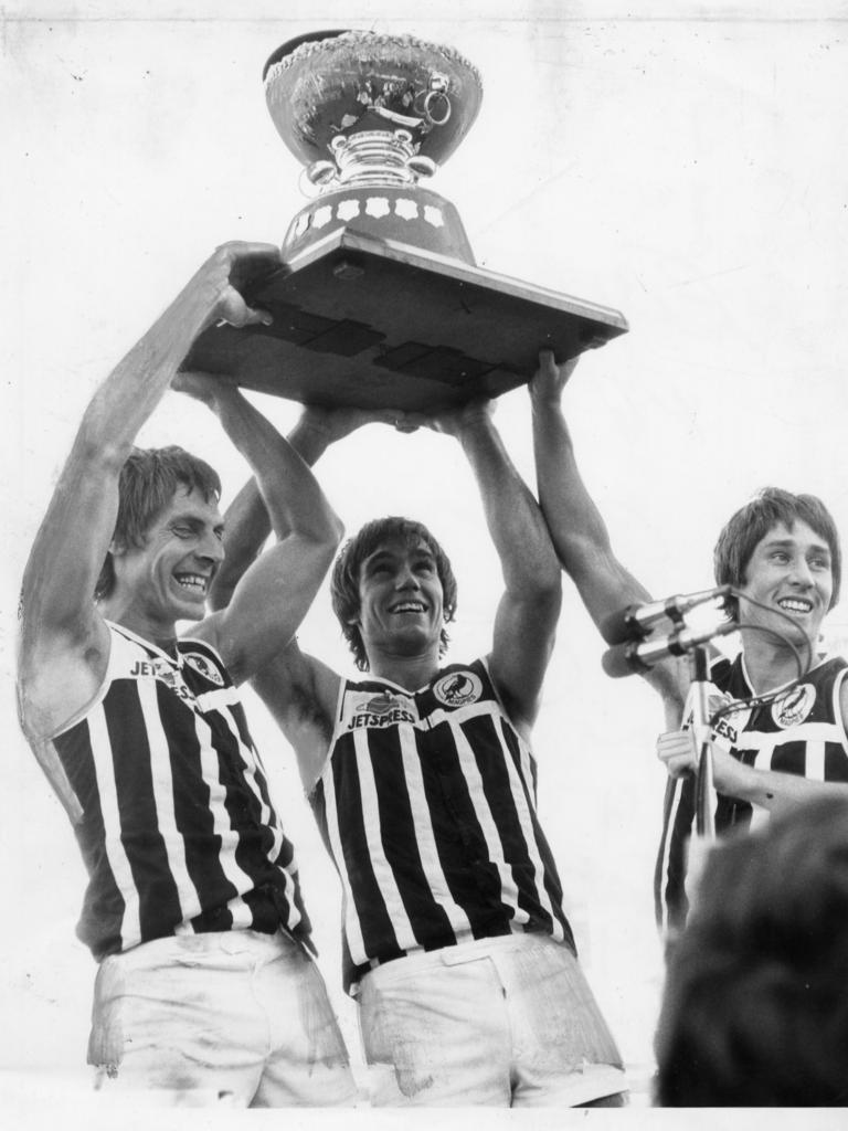 Port Adelaide footballers Russell Ebert, Greg Phillips and Brian Cunningham hold aloft the Thomas Seymour Hill trophy in 1980.