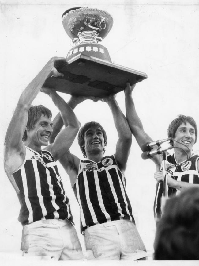 Port Adelaide footballers Russell Ebert, Greg Phillips and Brian Cunningham hold aloft the Thomas Seymour Hill trophy in 1980.