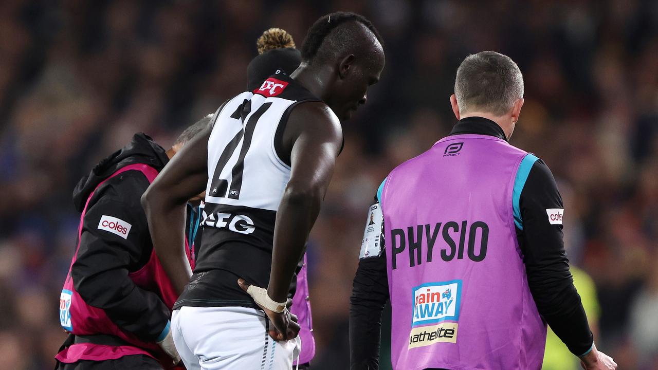 Aliir Aliir was helped from the field on Saturday night. Picture: Sarah Reed/AFL Photos