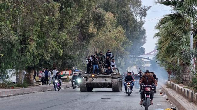 People ride a tank in the Syrian southern city of Daraa on December 7, 2024, after the collapse of government forces. Picture: AFP