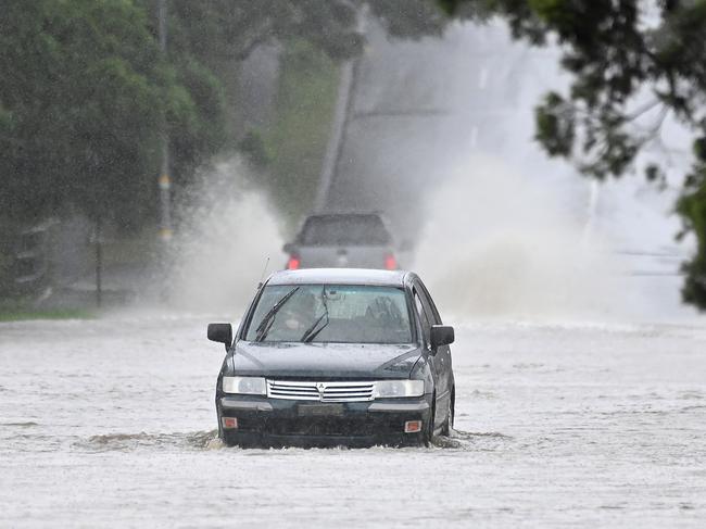 BRISBANE, AUSTRALIA - NewsWIRE Photos FEBRUARY 16, 2024:  Cars go through a flooded Shaw road in Kalinga.Wild and Wet weather in Brisbane.Picture: NCA NewsWIRE / John Gass