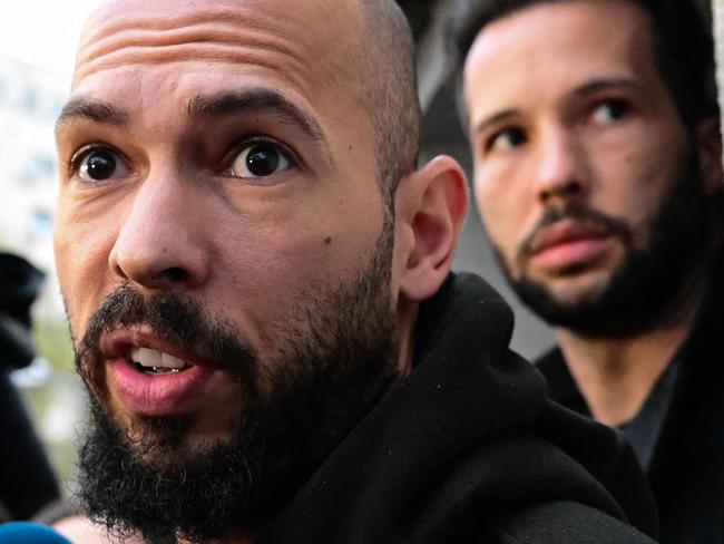 British-US former professional kickboxer and controversial influencer Andrew Tate (front) and his brother Tristan Tate (back R) speak to journalists after having been released from detention in Bucharest, Romania on March 12, 2024, after they appeared in a Bucharest court after Romanian police detained them over UK sex offence charges. A Bucharest court on March 12 granted a request to extradite controversial influencer Andrew Tate to the UK over sex offence charges, but only after the conclusion of legal proceedings in Romania in a separate case. The Bucharest appeals court ruling "orders the execution of the warrant of arrest issued on 19 January 2024" by the Westminster Magistrates' Court, but postpones extradition "until the final resolution of the case" in Romania, which could take years. (Photo by Daniel MIHAILESCU / AFP)