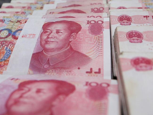 A teller counts yuan banknotes in a bank in Lianyungang, east China's Jiangsu province on August 11, 2015. China's central bank on August 11 devalued its yuan currency by nearly two percent against the US dollar, as authorities seek to push market reforms and bolster the world's second-largest economy. CHINA OUT AFP PHOTO