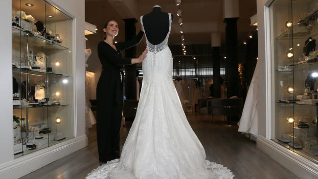 A worker from Sydney Road’s Raffaele Ciuca Bridal shop tends to one of the wedding dresses. Picture: George Salpigtidis.