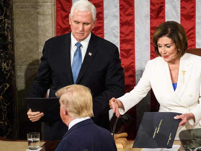 US Vice President Mike Pence (L) watches as House Speaker Nancy Pelosi reaches out to shake hands with US President Donald Trump. Picture: AFP