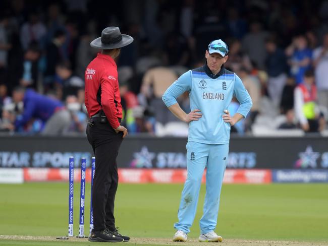 England's captain Eoin Morgan (R) speaks with umpire Kumar Dharmasena as he looks at the wicket after the New Zealand innings during the 2019 Cricket World Cup final between England and New Zealand at Lord's Cricket Ground in London on July 14, 2019. (Photo by Dibyangshu Sarkar / AFP) / RESTRICTED TO EDITORIAL USE