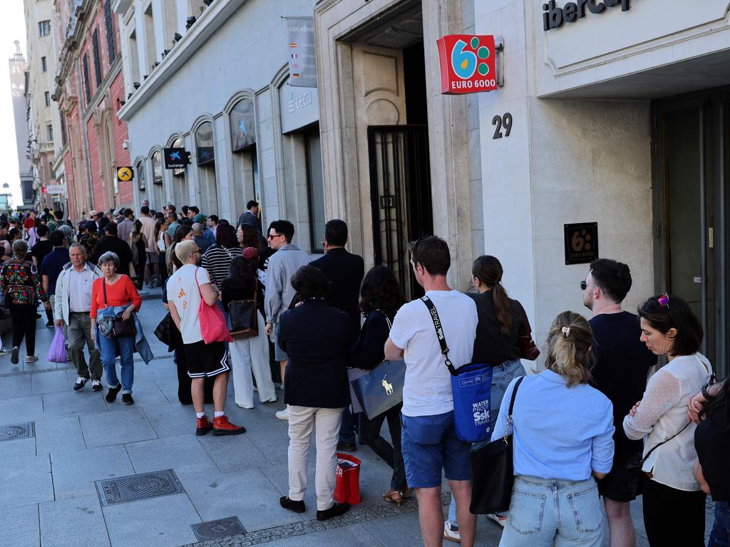 People queue to try to withdraw cash money at an ATM. Picture: Thomas Coex/AFP